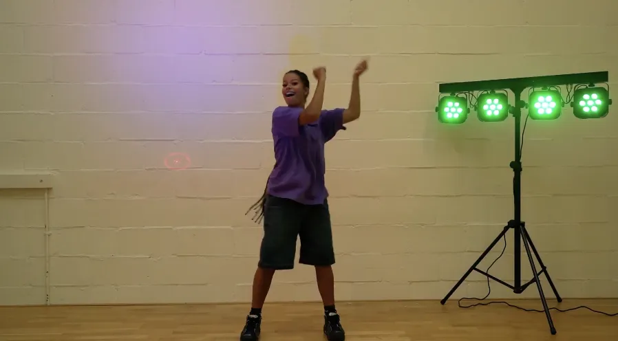 Pupil using a desk as a drum kit in a New Orleans Stomp rhythm routine